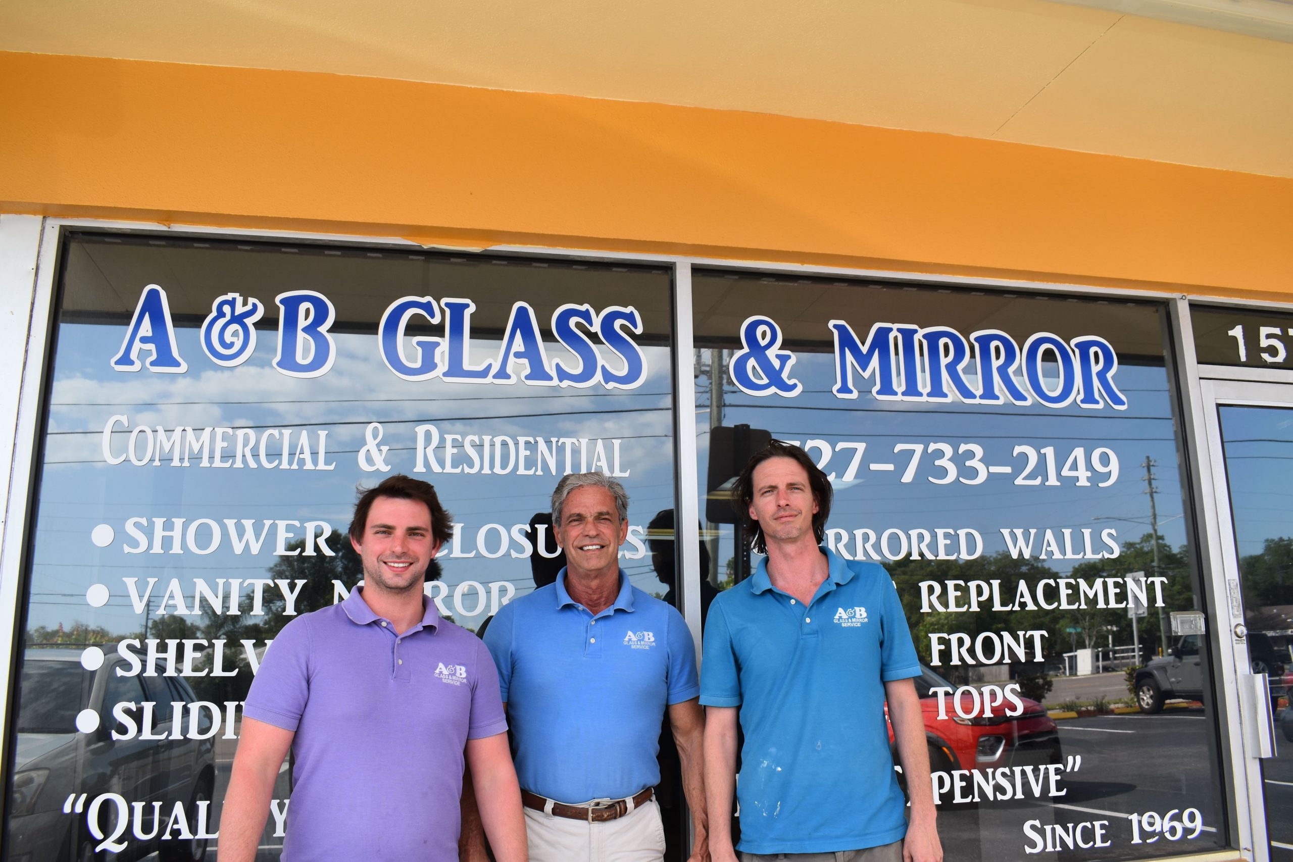 A & B Glass and Mirror Founder and Family in front of storefront